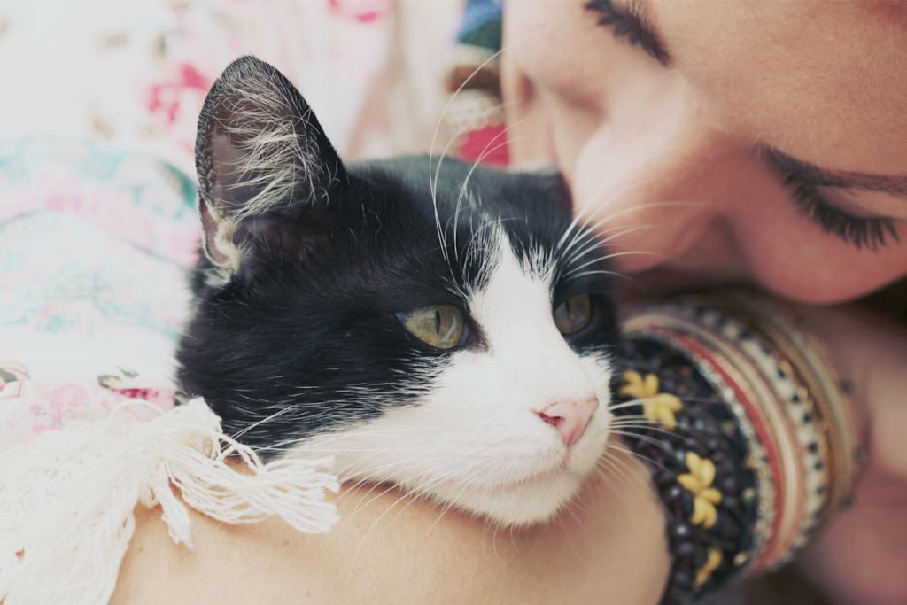 girl hugging cat wearing bracelets